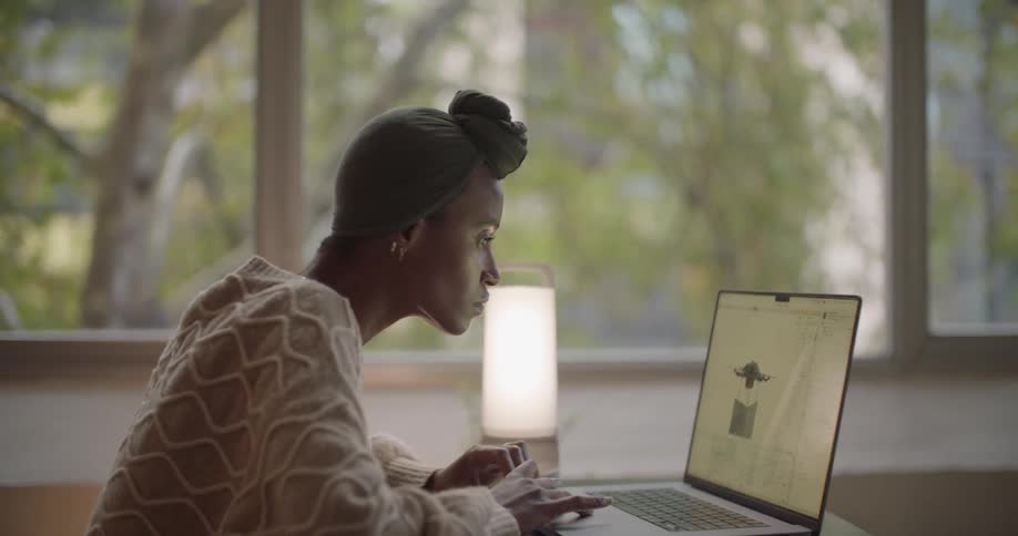 Young woman sitting at a table working on a laptop from home