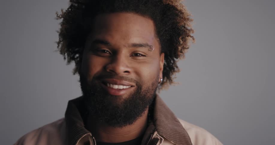 A man turns around and smiles into the camera it pans up to his face