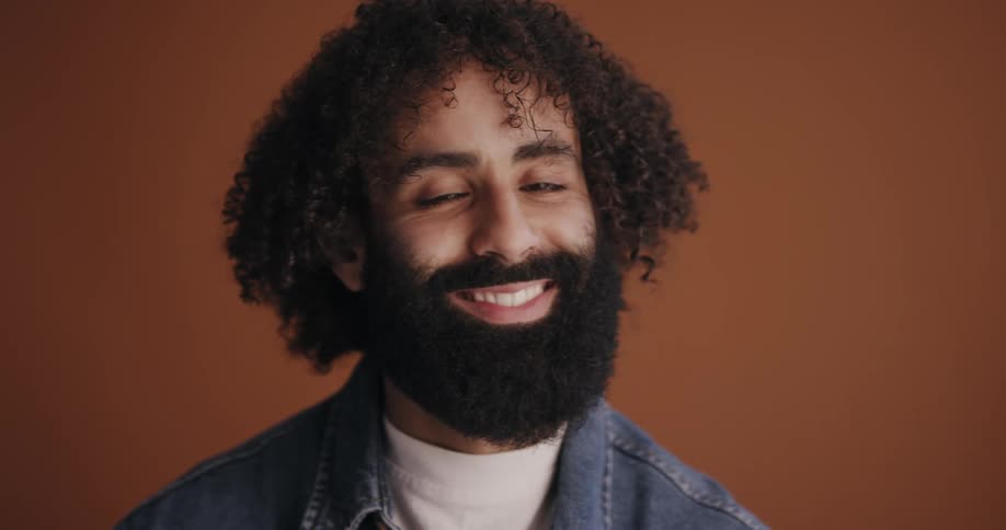 Close up of the face of a long haired bearded man looking at the camera