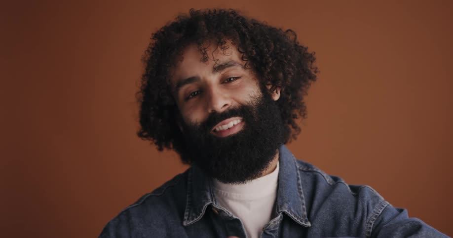 A man comes to sit before the camera and smiles into it