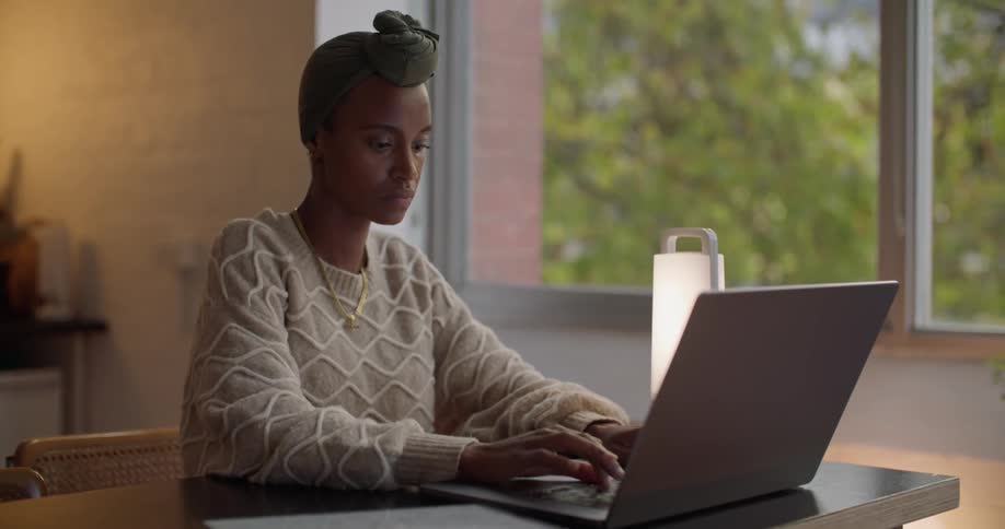 Young woman sitting at a desk at home working on a laptop