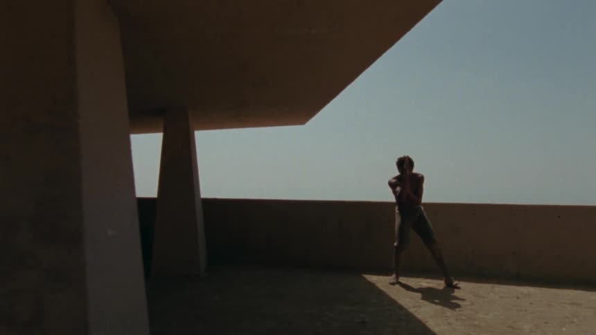 A man is practicing martial arts on a balcony
