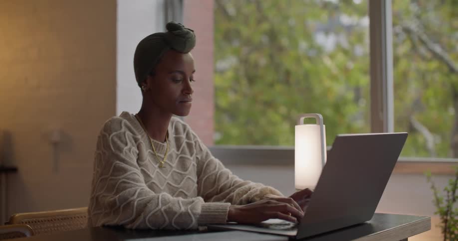 A woman is typing on her laptop