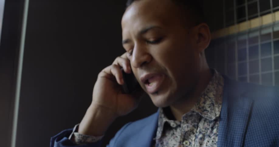 A man in a blue jacket talks on the phone
