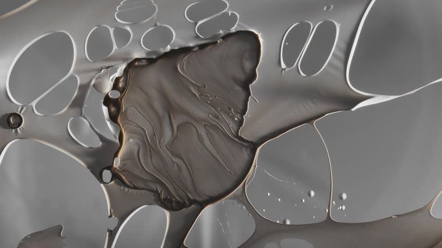 Dark liquid ink forming a film over a translucent surface and breaking