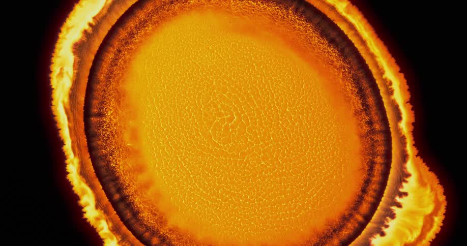 Big bright yellow blob of liquid ink pulsating on a black background