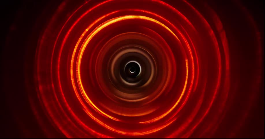 Concentric circles of bright red and yellow light shine against a dark background