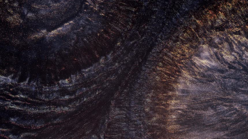 Dark glittering gold liquid ink flowing in concentric waves