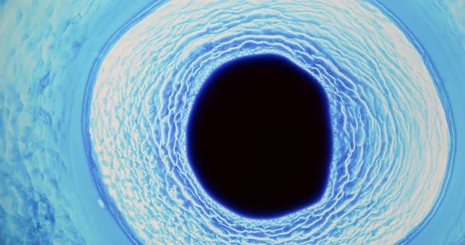 Dark blue liquid ink flowing out in concentric circles