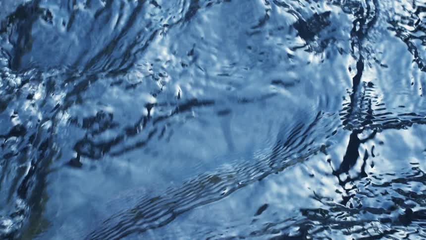 Flowing water ripples and forms bubbles
