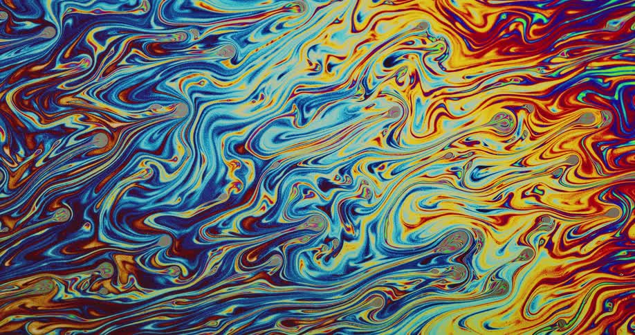 Different colors of liquids push into each other creating multicolored swirls