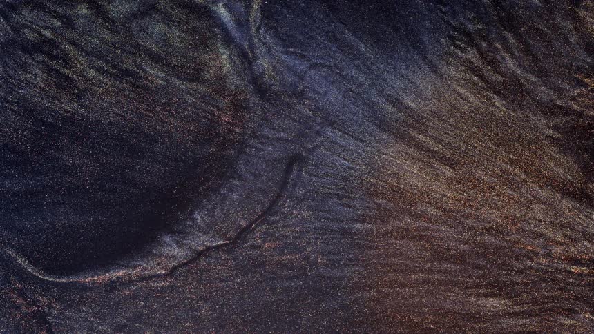 Flowing gold waves of glittering dark liquid ink