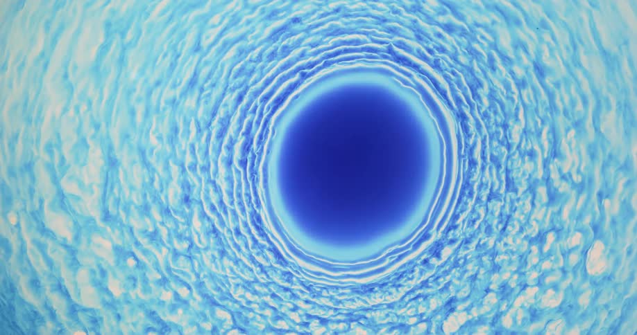 Blue liquid is mixing together in shapes