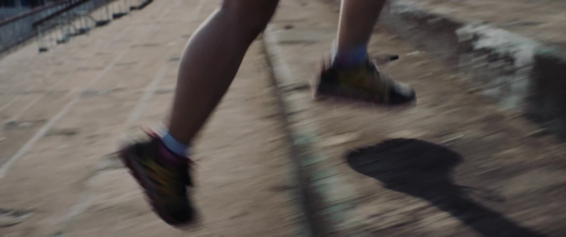 A person runs up a concrete staircase outdoors during the day