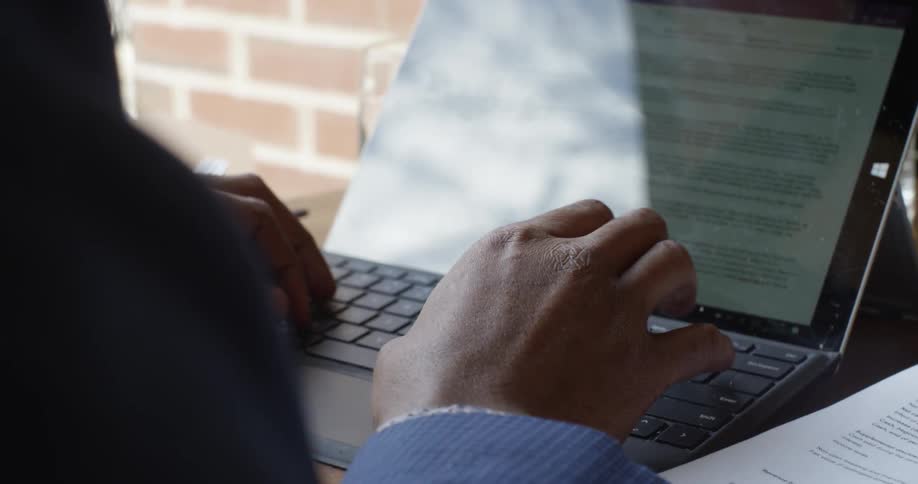 A person sitting and typing on laptop