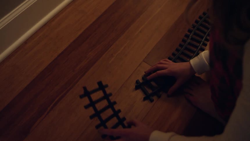 A person builds a toy train track