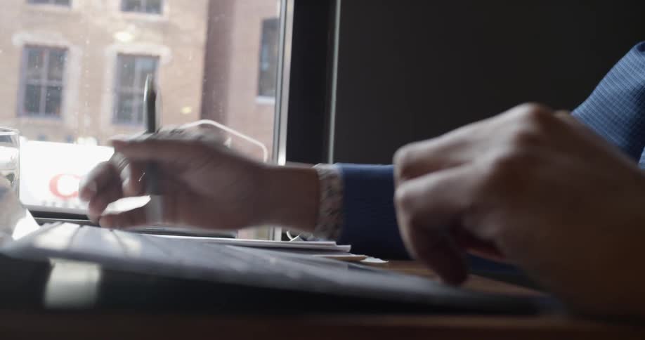 A man flips through papers and writes something down
