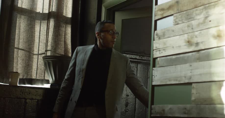 A man pulling a door closed as he exits a room