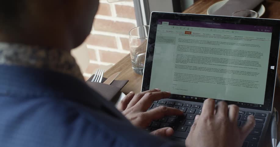 A man types on a laptop