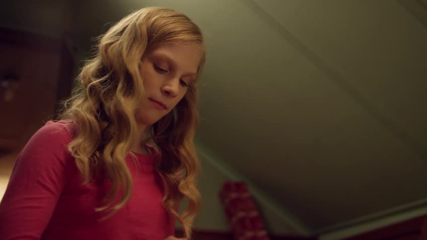 A blonde woman plays with a train tracks