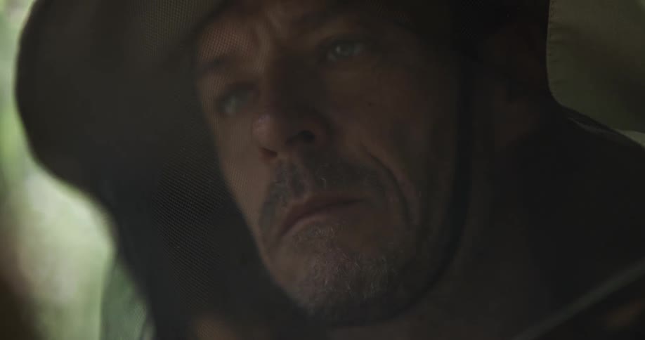 A man is standing outdoors and wearing a hat