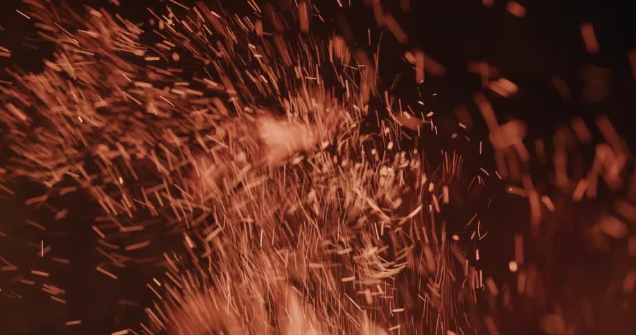 Flames waver as they burn brightly and sparks fly and smoke rises