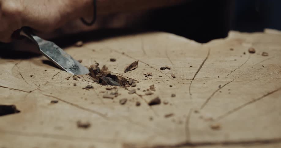A man chiseling wood