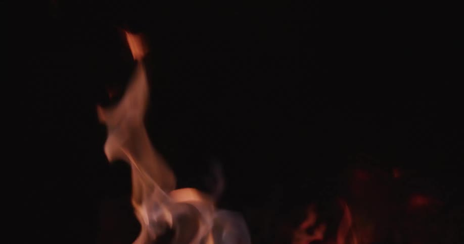Flames reach up as a fire burns in the night