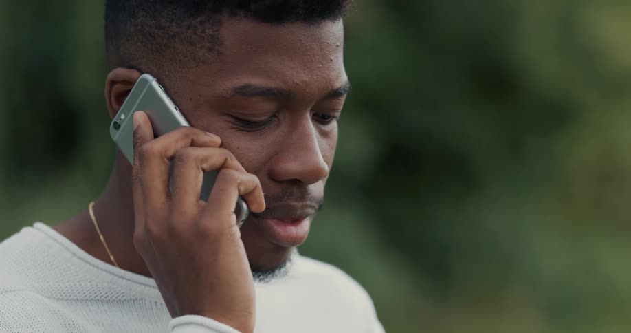 A man talking on a phone outdoors
