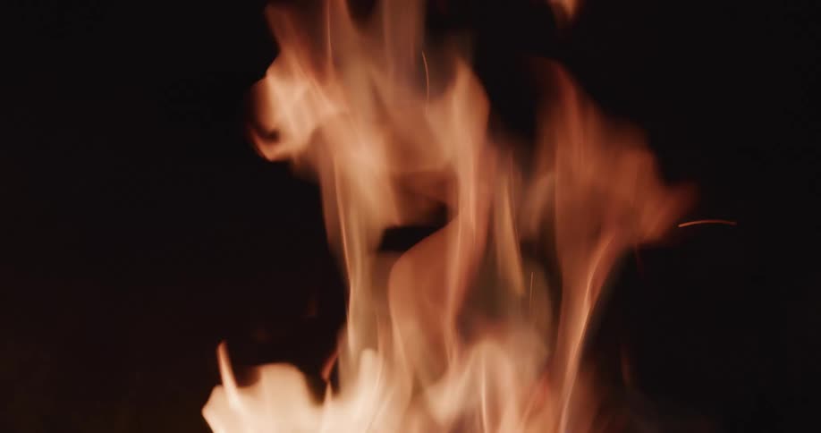 Flames waver wildly as a camp fire burns brightly and sparks fly