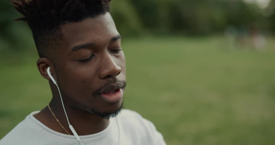 A man is outdoors and wearing headphones