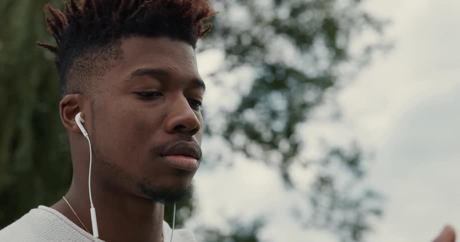 A man is outdoors and has headphones on