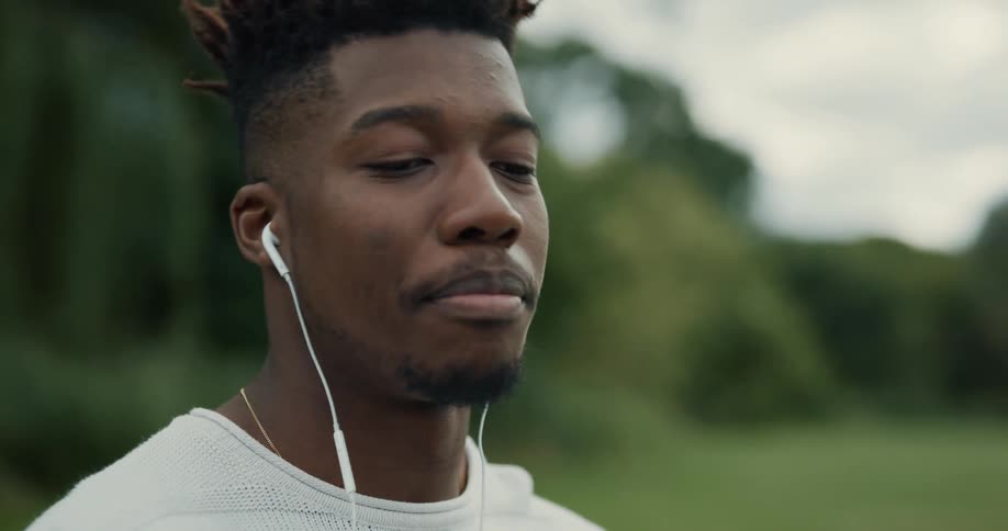 A man is smiling and talking to someone outdoors