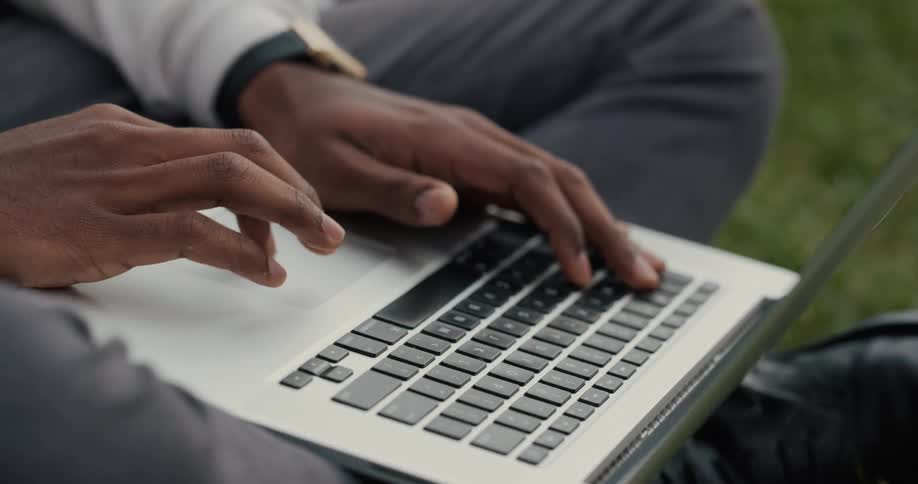 A man is typing on his laptop