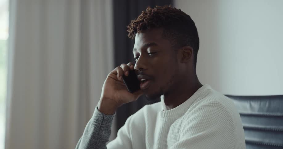 A man is smiling and talking on his cellphone