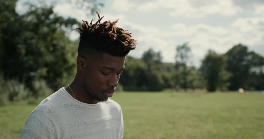 A man is standing outside in a field of grass