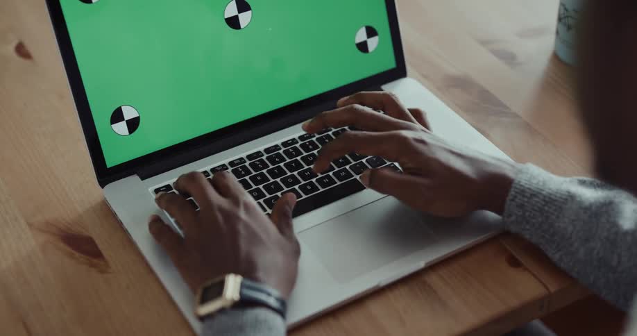 A person is typing on a laptop in a room