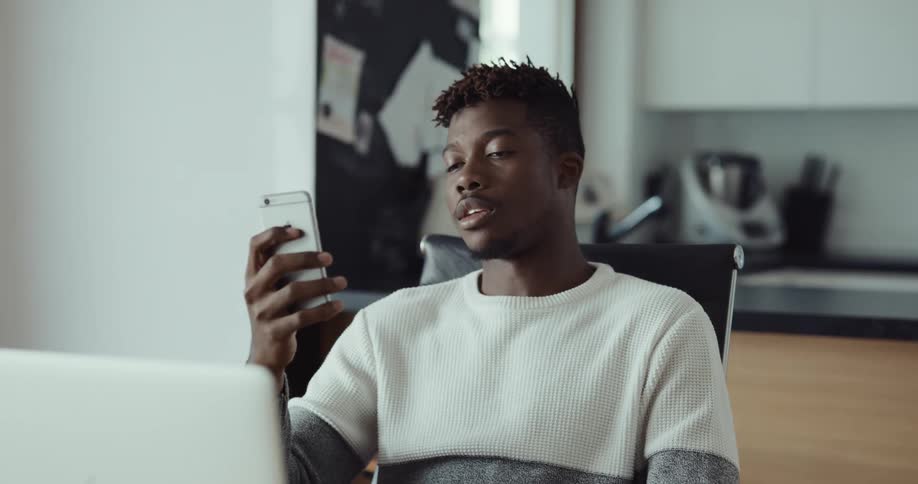 A man is video chatting with someone on his cell phone