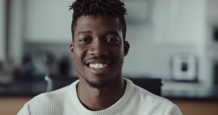 A man is smiling in a room in his house