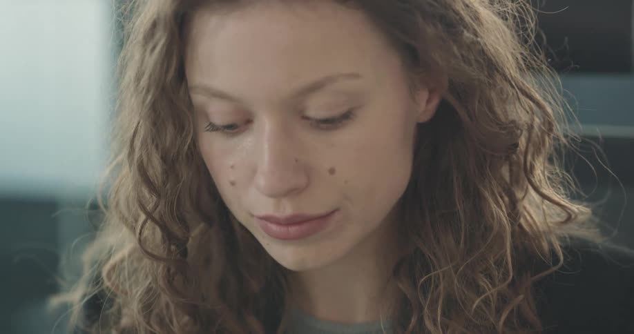 A woman is sitting in a room and is smiling