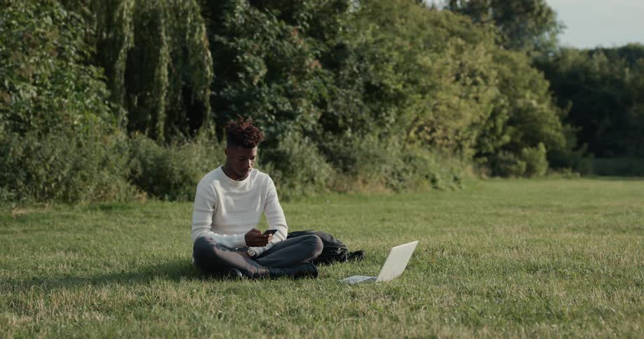 A man is sitting on the grass outdoors in spring