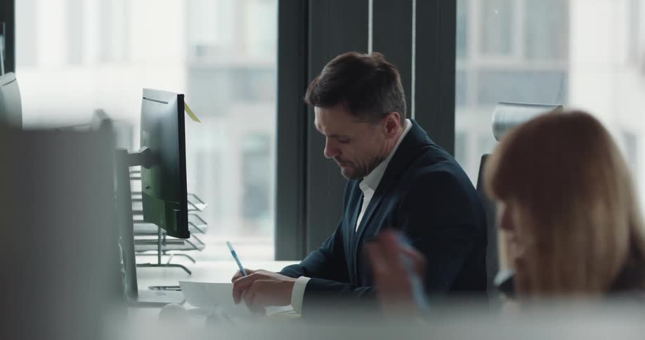 Group of business people sitting at desks on an office working on computers and making calls