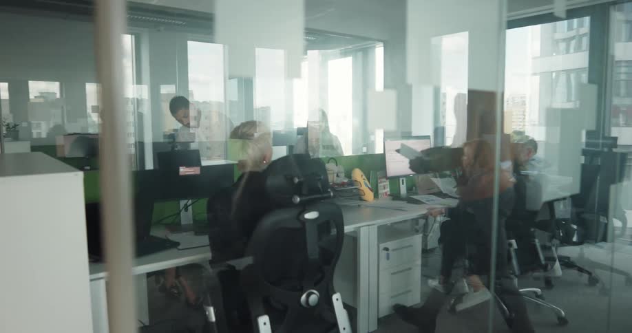A woman hurries to join her colleagues in a meeting room