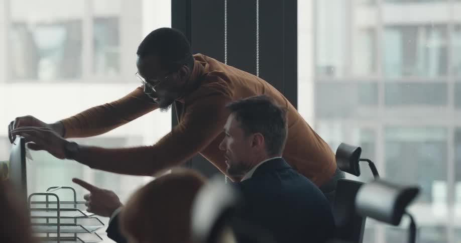 A group of workers is in an office using computers