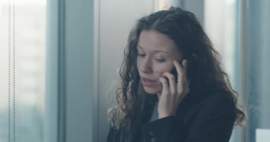 An office employee is talking on her cell phone