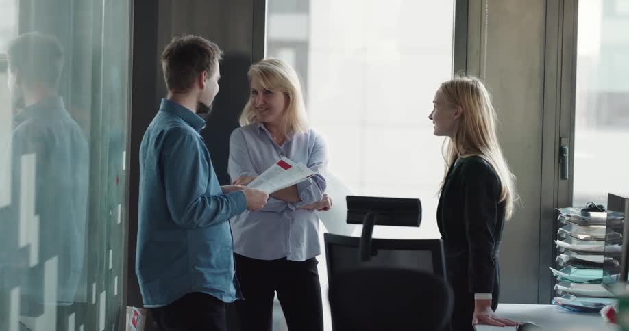 Coworkers gathered together talking in the office
