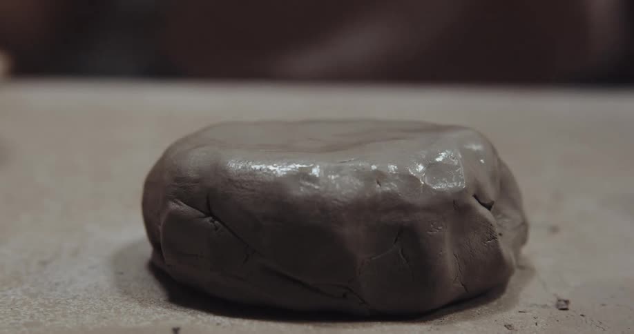 A person is forming clay into shapes