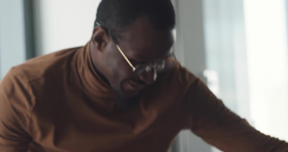 A man is startled as a colleague give him paperwork while he talks on the phone