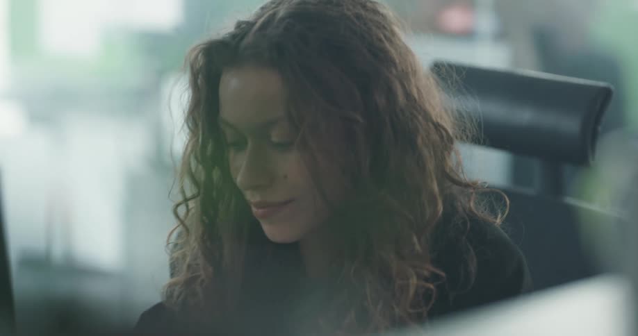 A woman is sitting at her desk in an office