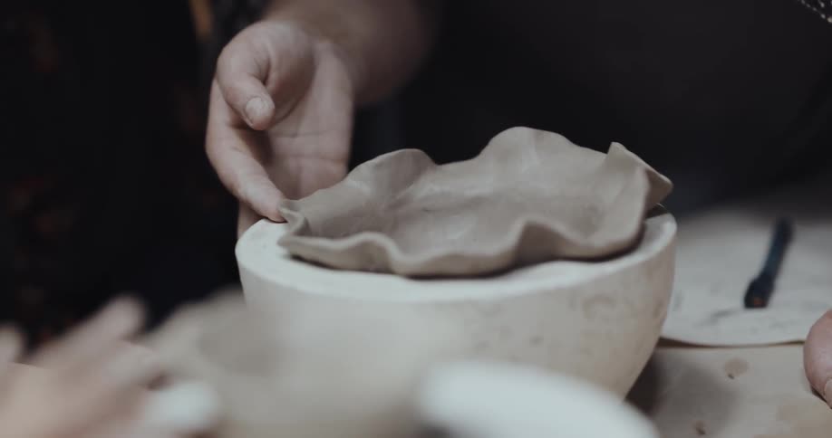 A woman is teaching someone how to sculpt